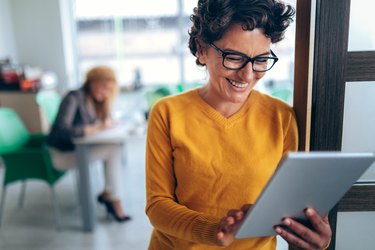 Smiling woman using tablet in the office
