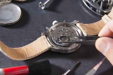 Detail of the work of a watchmaker who replaces a battery