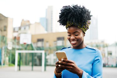 Woman using smart phone in city